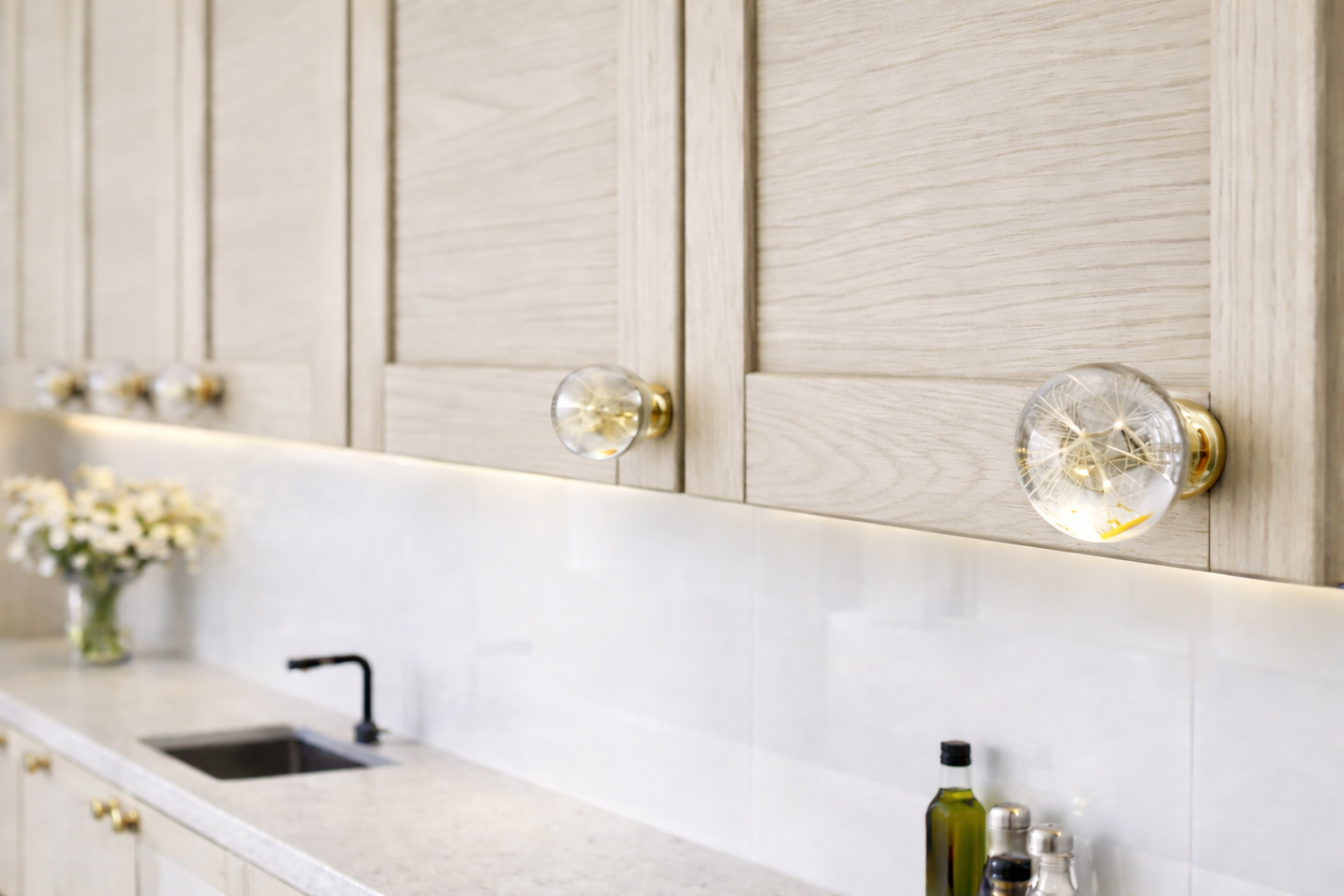 Modern kitchen with light wood cabinets, dandelion resin knobs with golden base