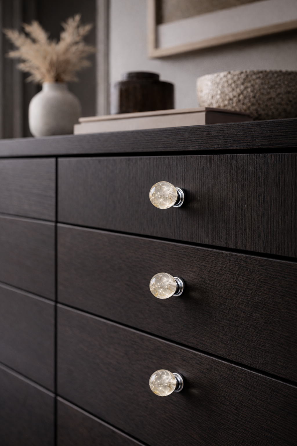Dark wooden dresser with delicate knobs in a room setting.