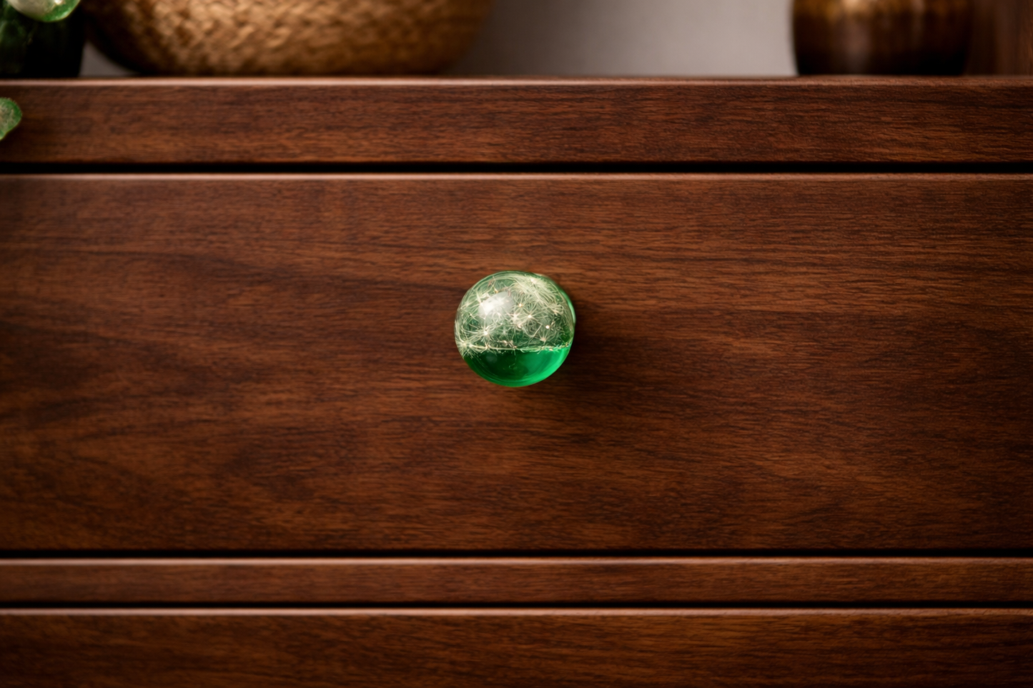 Handmade green resin cabinet knob with real dandelion seeds mounted on dark wooden drawer – botanical furniture hardware