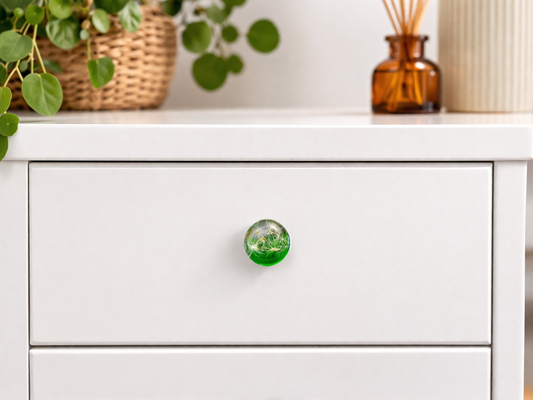 Handmade green resin cabinet knob with real dandelion seeds installed on white drawer front – botanical furniture hardware