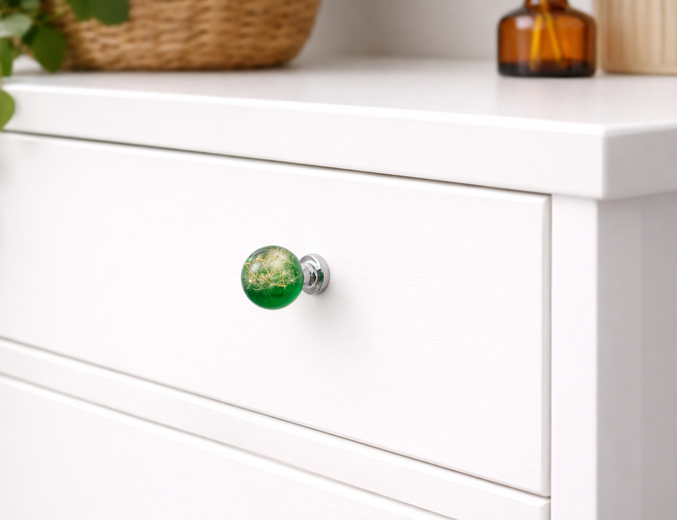 Green resin drawer knob with preserved dandelion seeds on white dresser drawer