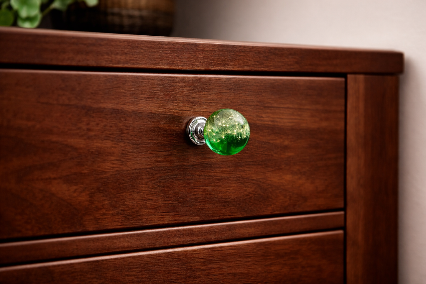 Handmade green resin cabinet knob with real dandelion seeds installed on dark wood drawer – botanical furniture hardware